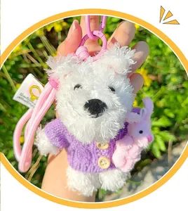 Close-up detail of a West Highland White Terrier plush keychain wearing a cute purple sweater