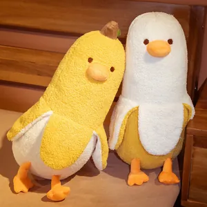 Cute banana duck plush toy pillow with soft fleece texture in a warm bedroom setting