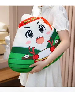 Close-up of a cute Zongzi-shaped plush pillow with cartoon face being held by a person
