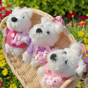 Three cute Westie plush dog keychains wearing colorful sweaters sitting in a wicker basket