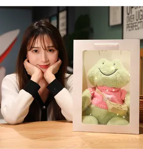 Peluche de rana verde sonriente en bolsa de regalo con luces y modelo asiática