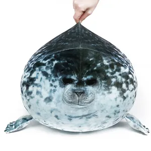 Soffice cuscino di peluche a forma di foca con trama grigia maculata su sfondo bianco.