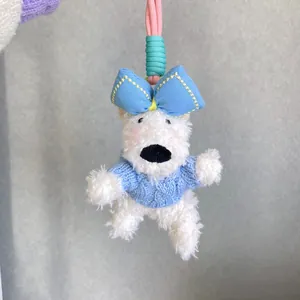 Adorable white Westie plush dog keychain wearing a blue knitted sweater and bow