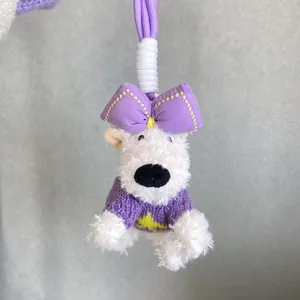 Adorable white Westie plush dog bag charm featuring a purple bow and knitted sweater