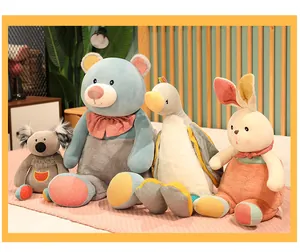 Group of cute plush animal toys including bear and rabbit sitting on a cozy bed