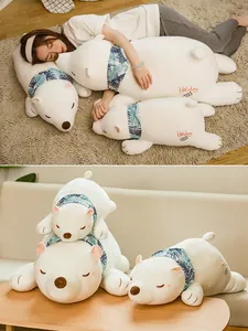 Detail view of white polar bear plush toy pillows featuring floral scarves and embroidery