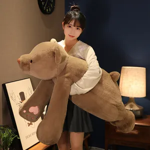 Soft brown plush teddy bear stuffed animal pillow held by an Asian girl in cozy bedroom