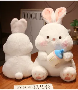 Front and back view of a soft plush rabbit toy holding a blue baby bottle