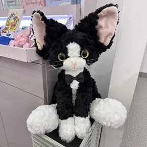 Large black and white Devon Rex cat plush toy with curly fur and cute bowtie.