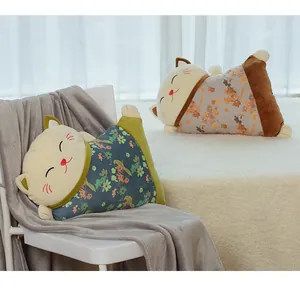 Dos lindos cojines gato Maneki-neko 2 en 1 con motivos florales sobre una silla