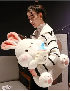 Cuddly large white rabbit plush toy with a milk bottle accessory held by a model
