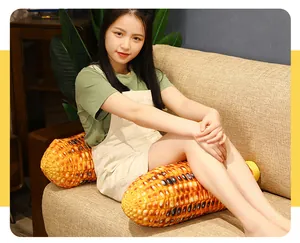 Close-up of a realistic roasted corn plush pillow held by a model on a cozy sofa