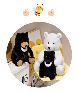 Nahaufnahme von realistischen Schwarzbär- und Eisbär-Plüschtieren auf einem Stuhl.