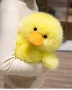 Detail showing the soft fluffy texture of a cute yellow duck plush toy held in arms.