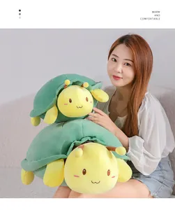 Asian model holding two stacked green turtle bee plush toys in a cozy living room