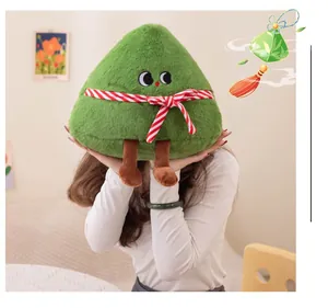 Primo piano di un simpatico peluche Zongzi verde con gambe per la Festa delle Barche Drago