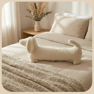 Coussin en peluche en forme de teckel crème en polaire sherpa douillet sur un lit