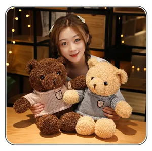 Close-up detailed view of soft brown and beige teddy bears with cozy knitted sweaters