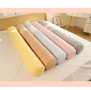 Une rangée de traversins cylindriques colorés en tissu minky doux avec des picots