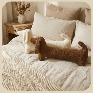 Coussins teckel en fausse laine d'alpaga blanche et marron sur un lit douillet et chaud