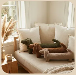Vue détaillée de coussins en peluche en forme de teckel sur un canapé beige