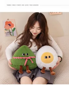 Simpatici peluche di zongzi e uovo sodo tenuti da una modella in un ambiente accogliente