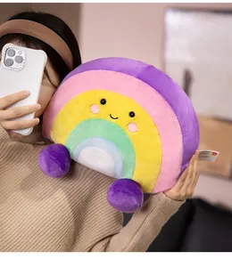 Close-up detail of a colorful cartoon rainbow plush pillow with a cute embroidered smiley face