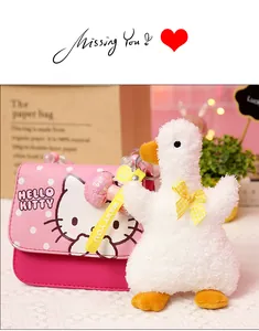 Close-up detail of a white fluffy duck keychain featuring a yellow bow and ribbon