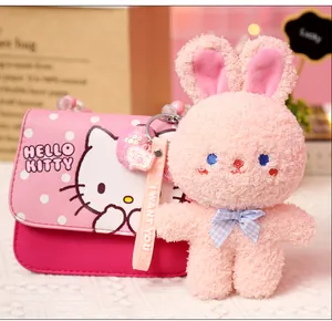 Close-up detail of a pink plush rabbit charm together with a cute Hello Kitty mini handbag