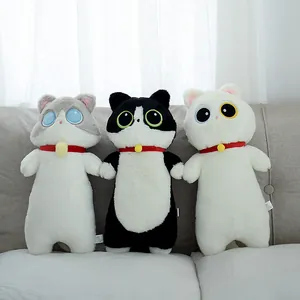 Lot de trois coussins chat en peluche aux grands yeux sur un canapé douillet