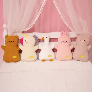 Collection of five soft animal plush pillows on a bed, including rabbit and bear