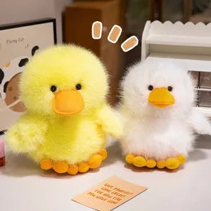 Two cute fluffy yellow and white duck plush toys presented in a cozy indoor home setting.