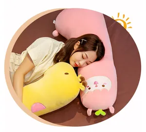 Jeune femme dormant confortablement avec de longs oreillers en peluche sur un lit douillet