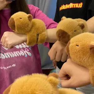 Détail de jolis bracelets en peluche capybara marron portés sur plusieurs poignets par des personnes
