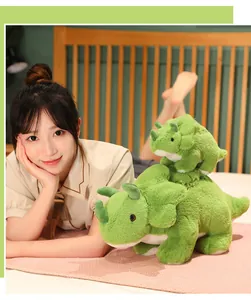 Dos adorables peluches de triceratops verdes de diferentes tamaños sobre una cama.