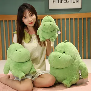 Adorable chubby green dinosaur plush animal doll for children in a cozy bedroom
