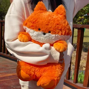 Peluche de zorro naranja suave con pelo blanco esponjoso sostenido al aire libre