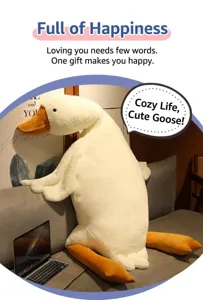 Giant plush white goose body pillow on a grey sofa next to a laptop