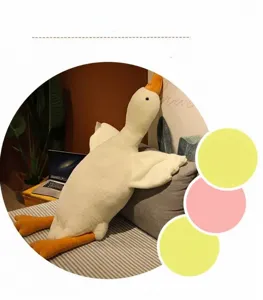 Large white goose plush pillow leaning on a gray sofa in a cozy home setting