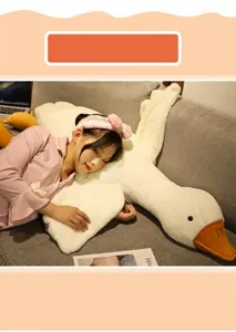Detail view of a soft plush white goose body pillow being used for sleeping on a sofa.