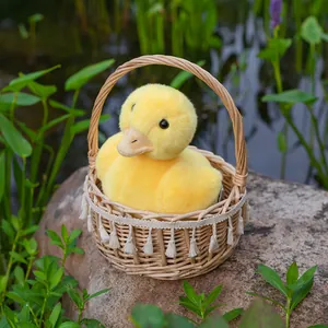 Super soft realistic yellow duck plush toy sitting inside a charming woven basket outdoors