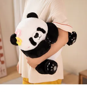 Close-up of a soft panda plush toy with colorful flower accents held by a person