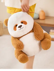 Adorable brown and white panda plush toy held by a child in a cozy warm home setting
