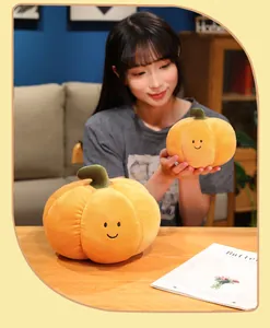 Smiling young woman holding a cute orange pumpkin plush toy in a warm cozy room