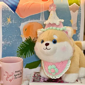 Adorable Shiba Inu dog plush toy wearing a pink crochet party hat and bib for birthdays.