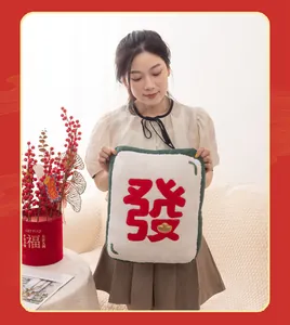 Close-up of a festive mahjong plush pillow with 'Fa' character for Lunar New Year.