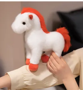 Nahaufnahme eines weichen weißen Plüschponys mit leuchtend oranger Mähne und Schweif