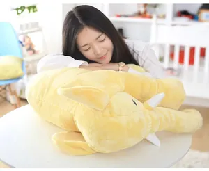 Soft plush elephant soothing pillow shown being used by a model in a home setting