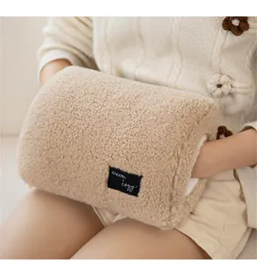 Close-up van een zachte beige pluche handwarmer mof met warm and cozy label detail