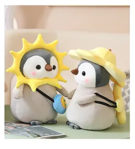 Dos lindos peluches de pingüino con disfraces de girasol y sombrero amarillo para el sol
